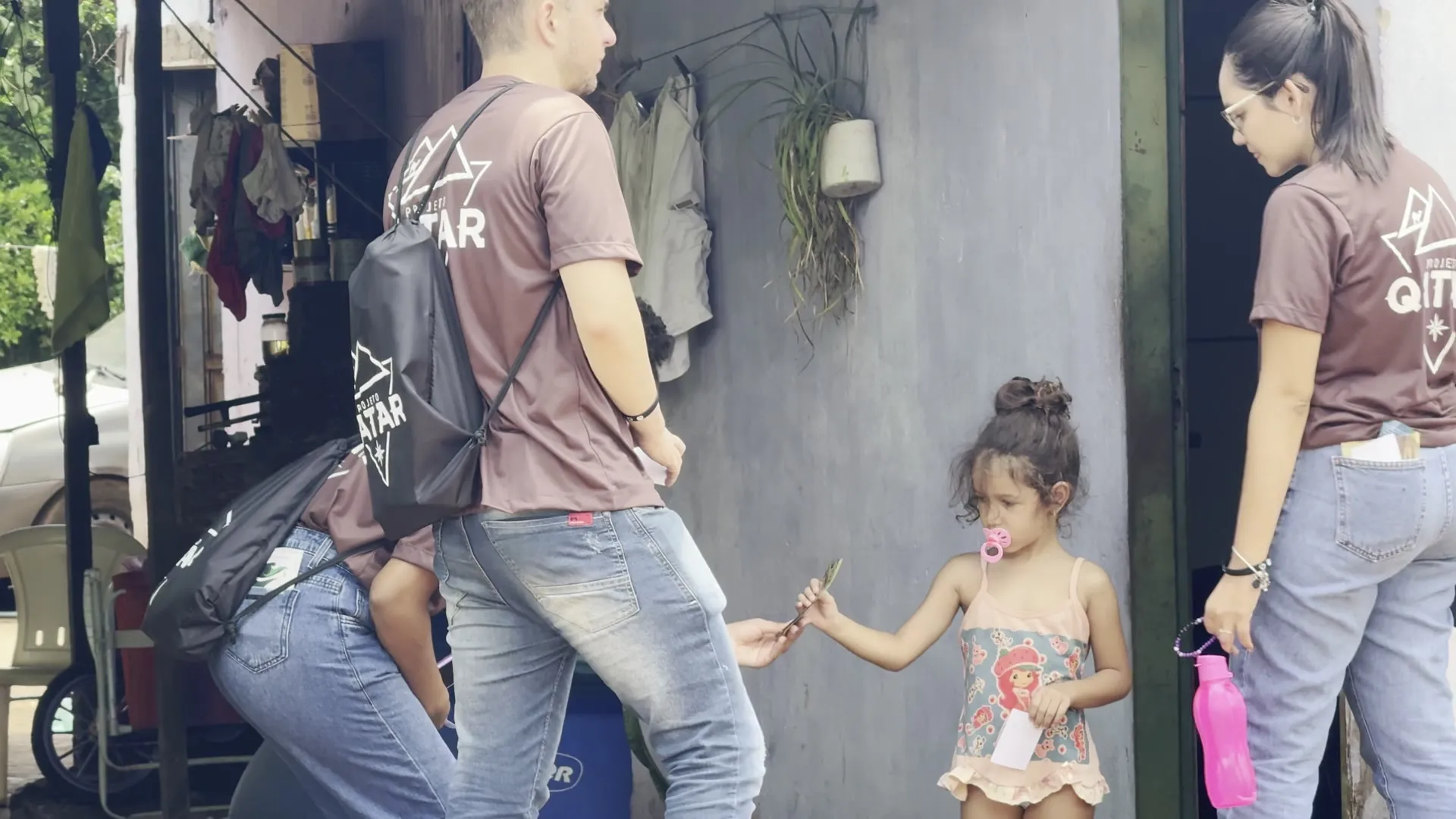 Missionário do Qatar conversa com uma criança na porta de casa