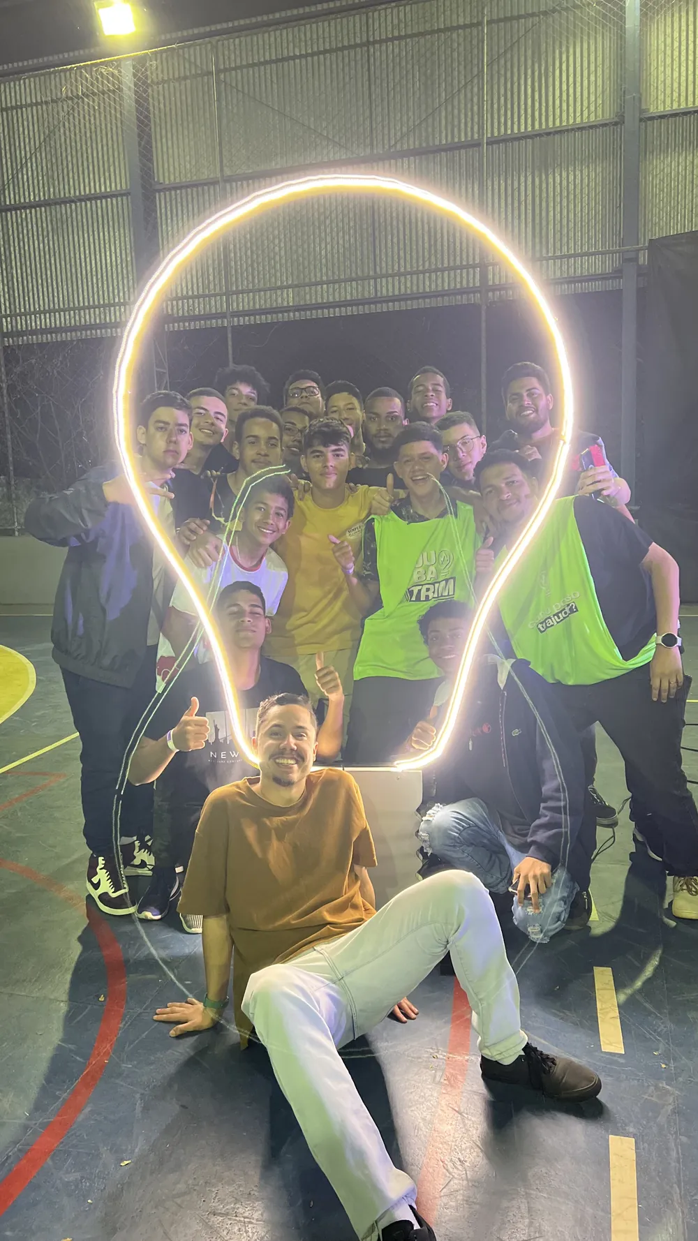 Jovens dentro da lâmpada neon da JUBATRIM no Conjubatrim 2023